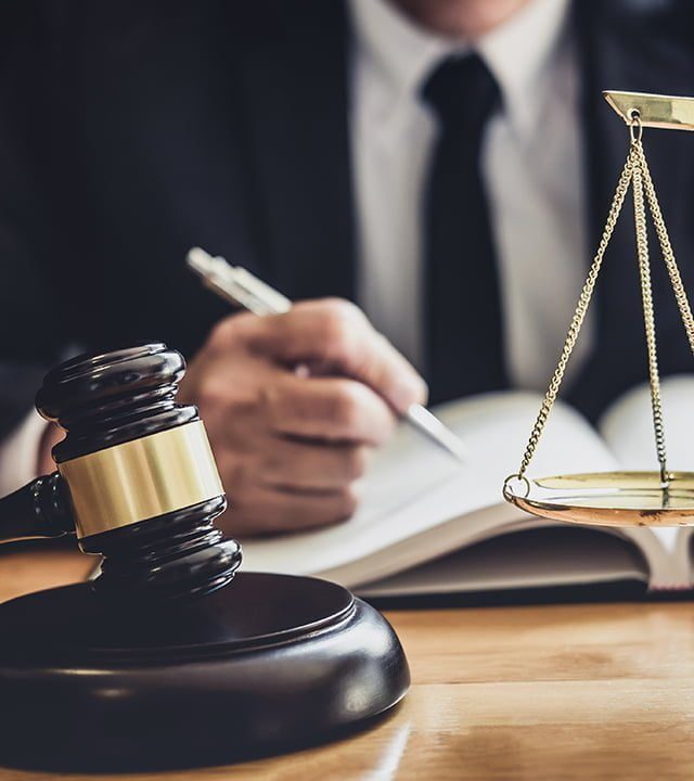 Male lawyer or judge working with contract papers, Law books and wooden gavel on table in courtroom, Justice lawyers at law firm, Law and Legal services concept.